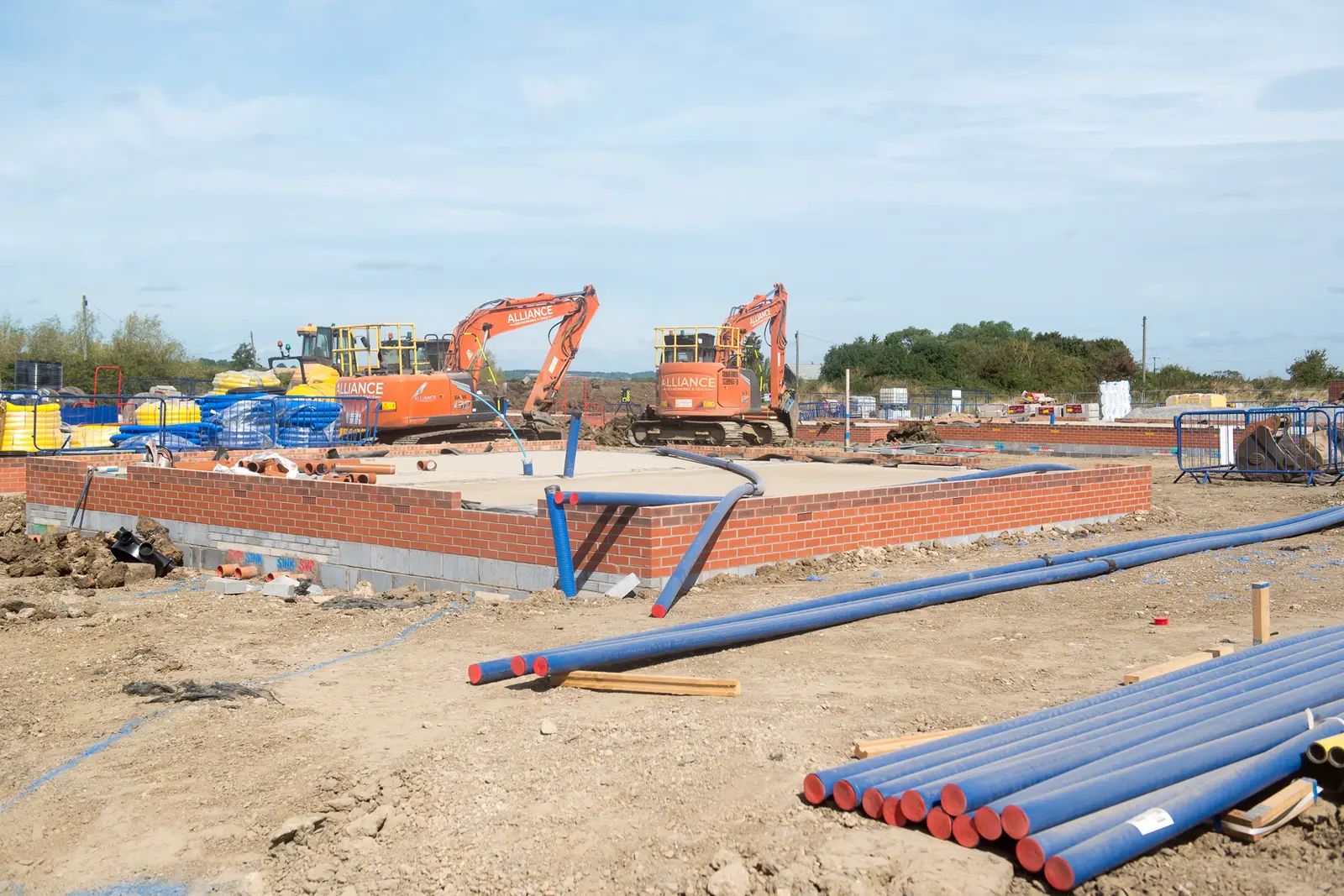Excavators on the Airfield House development site with foundations being built in the foreground