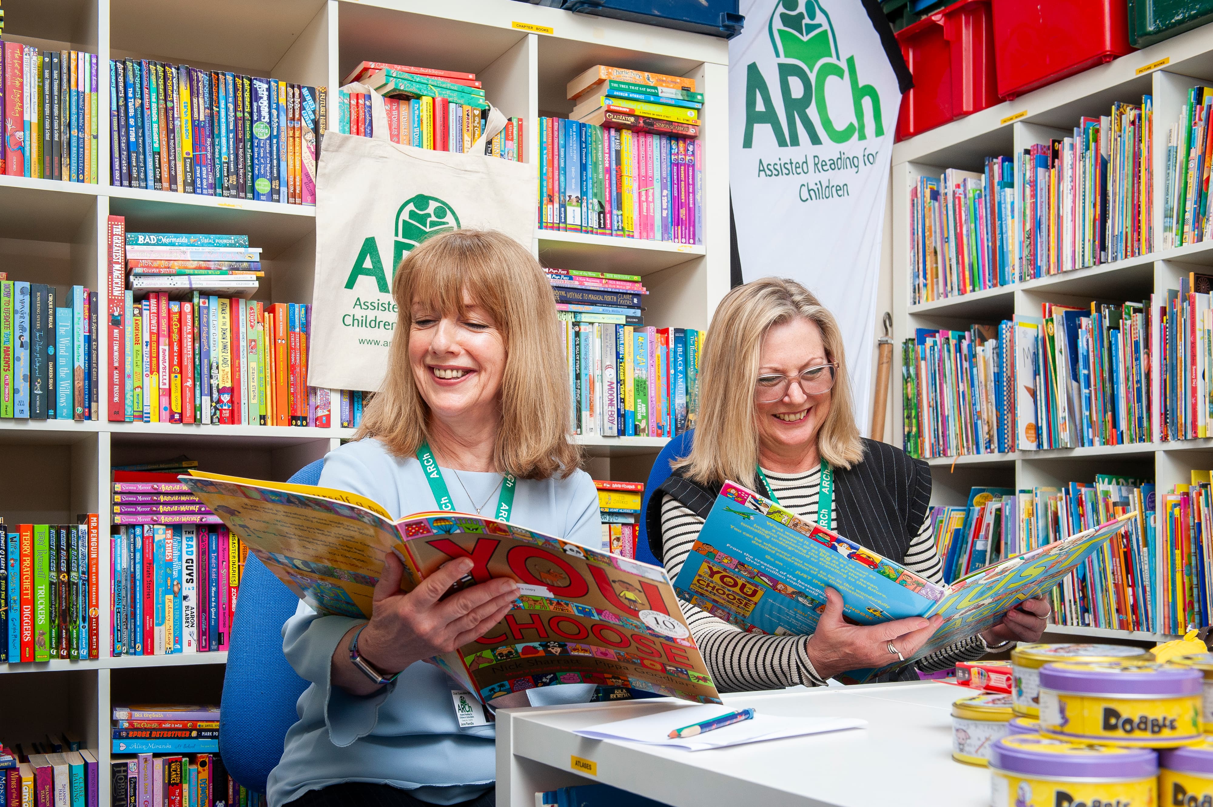 Two volunteers from ARCh reading children's books.