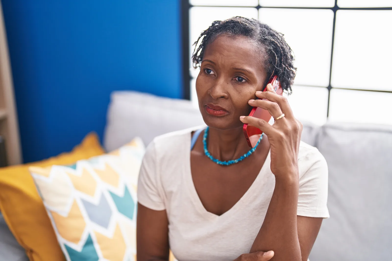 A woman looking concerned while talking on the phone
