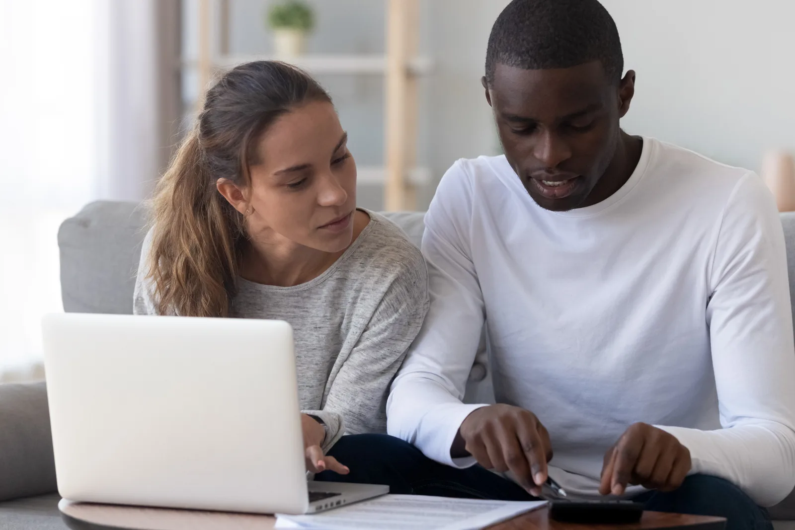 A young couple sitting together looking at a laptop