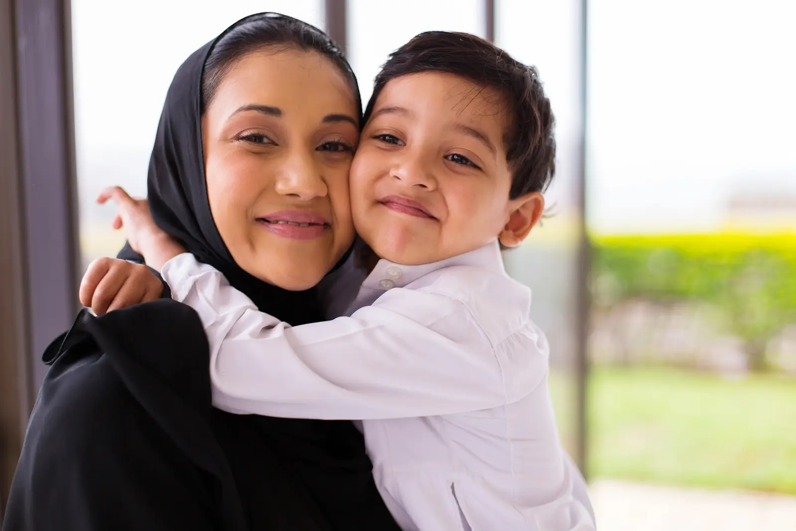 A young boy hugging his mother