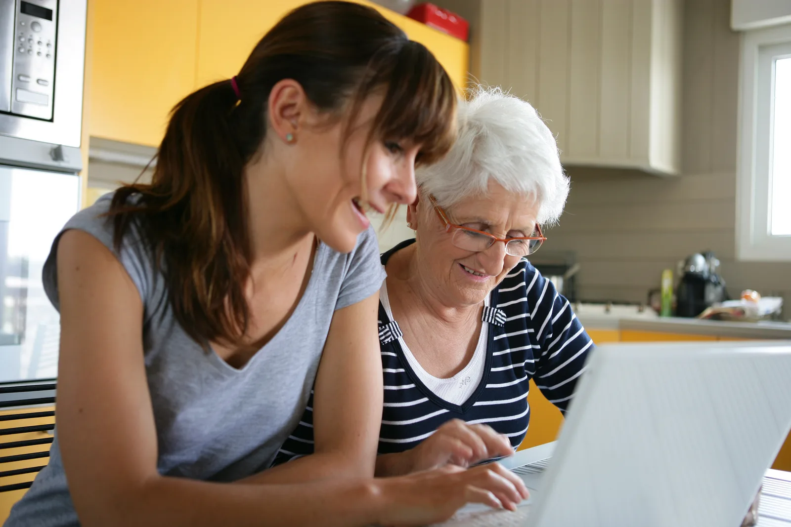 An elderly woman and her daughter using a laptop